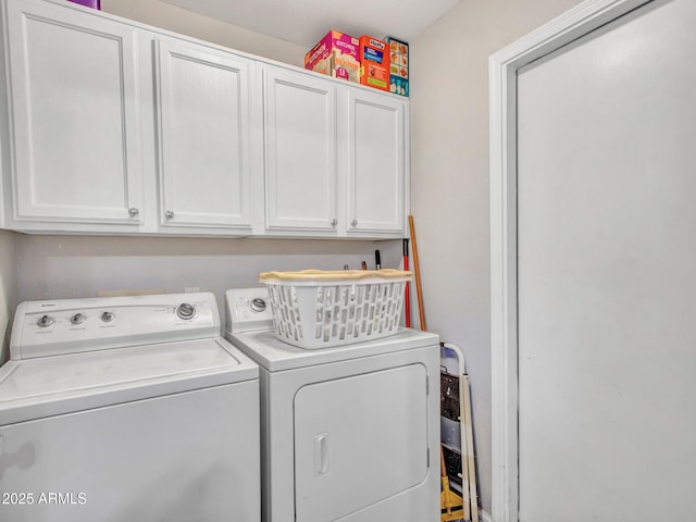 clothes washing area featuring cabinets and washer and dryer