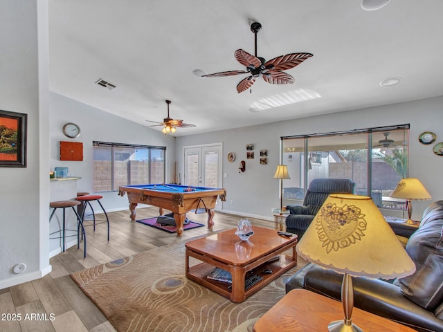 living room featuring pool table, a wealth of natural light, vaulted ceiling, and light wood-type flooring