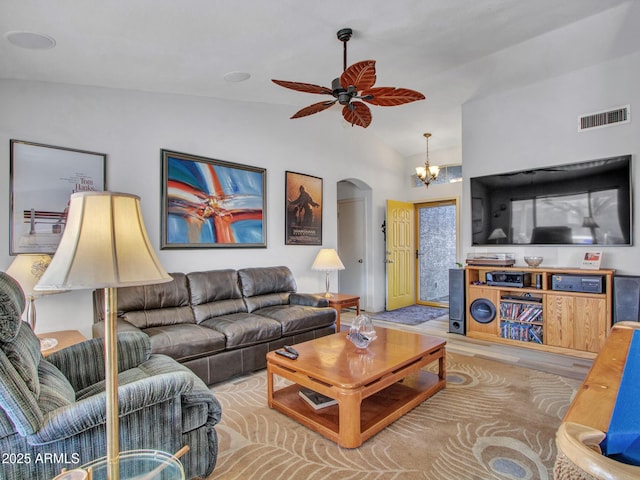 living room with ceiling fan with notable chandelier, vaulted ceiling, and light wood-type flooring