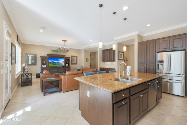 kitchen featuring stainless steel appliances, a kitchen island with sink, light stone counters, and dark brown cabinets