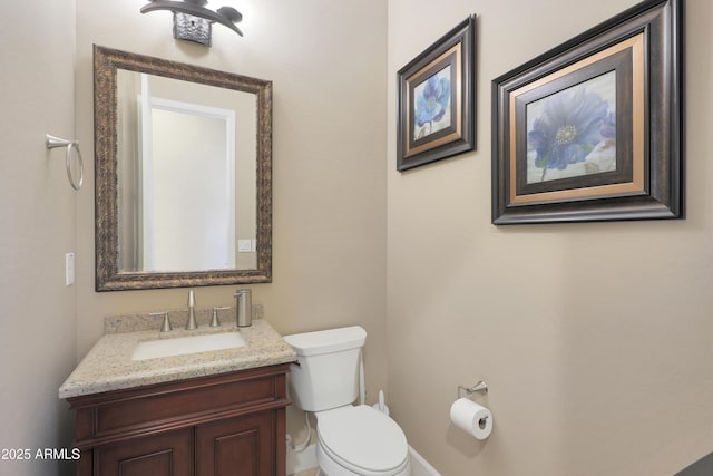 half bathroom with vanity and toilet