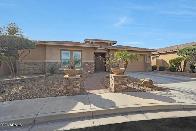 prairie-style home featuring a garage, stone siding, concrete driveway, and stucco siding