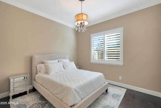 bedroom featuring a notable chandelier, crown molding, baseboards, and wood finished floors