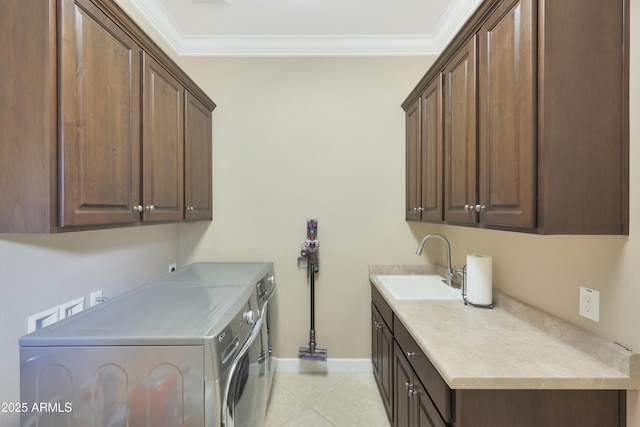 clothes washing area with cabinet space, ornamental molding, washer and clothes dryer, and a sink