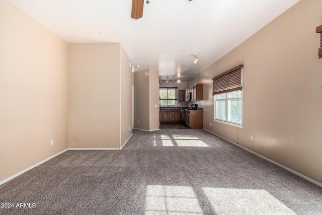 unfurnished living room with ceiling fan and carpet floors