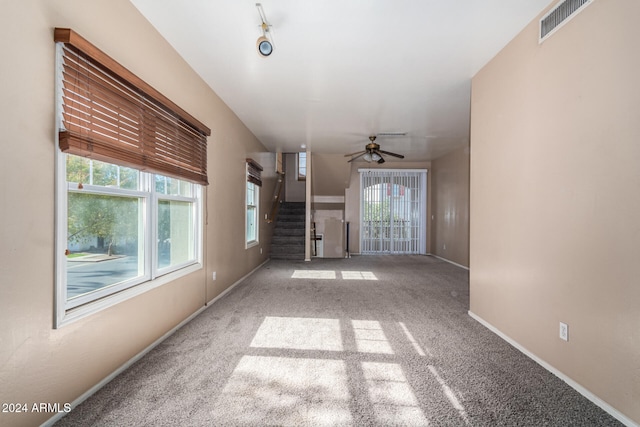 unfurnished living room featuring carpet and ceiling fan