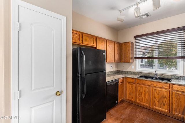 kitchen with light stone countertops, sink, rail lighting, dark hardwood / wood-style flooring, and black appliances