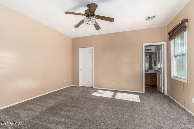 unfurnished bedroom featuring ensuite bathroom, ceiling fan, and carpet floors