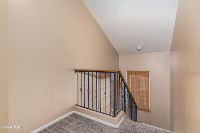 staircase with carpet flooring and lofted ceiling