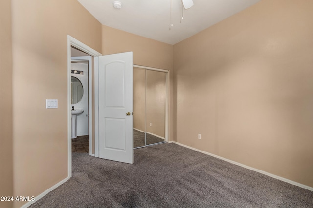 unfurnished bedroom with dark colored carpet and ceiling fan