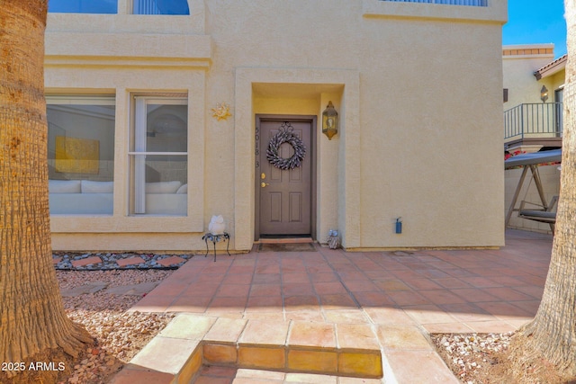 view of exterior entry with a patio