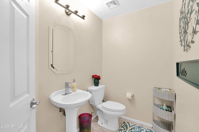 bathroom with heating unit, tile patterned floors, and toilet