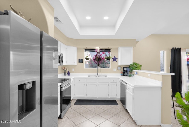 kitchen featuring sink, white cabinetry, light tile patterned floors, a tray ceiling, and stainless steel appliances