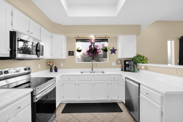 kitchen with light tile patterned flooring, a raised ceiling, white cabinetry, sink, and stainless steel appliances