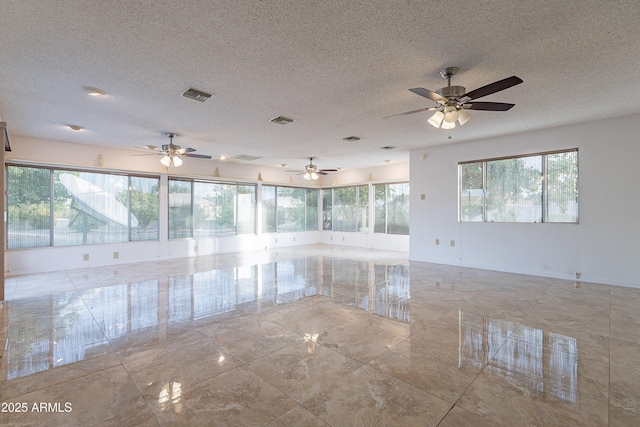 unfurnished room featuring ceiling fan and a textured ceiling