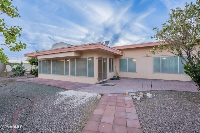 back of property featuring a sunroom and a patio