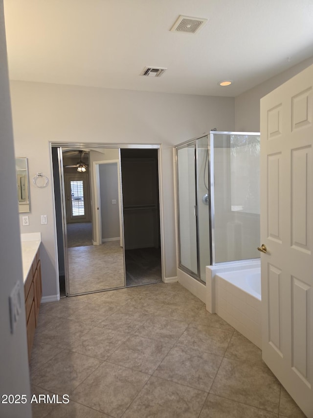 14621 W Catalina Dr, Goodyear, AZ 85395 - bathroom with vanity, a stall shower, a garden tub, ceiling fan, and tile patterned floors