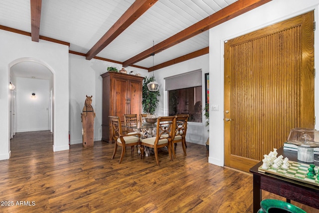 dining space with baseboards, beam ceiling, arched walkways, and dark wood-style flooring