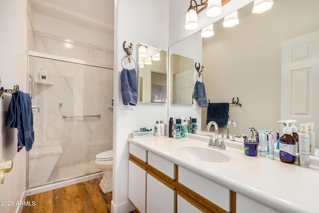 full bath with vanity, wood finished floors, a marble finish shower, and toilet