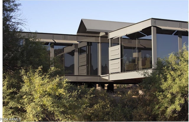 rear view of property featuring a sunroom