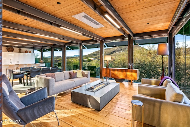 sunroom featuring beam ceiling and a mountain view