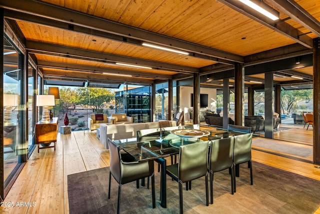 dining area with wood-type flooring, a wealth of natural light, and floor to ceiling windows