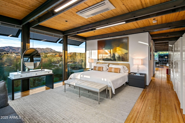 bedroom with floor to ceiling windows, beamed ceiling, a mountain view, wood-type flooring, and wood ceiling