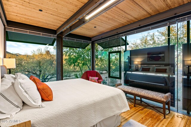 bedroom featuring wood-type flooring, wood ceiling, and multiple windows