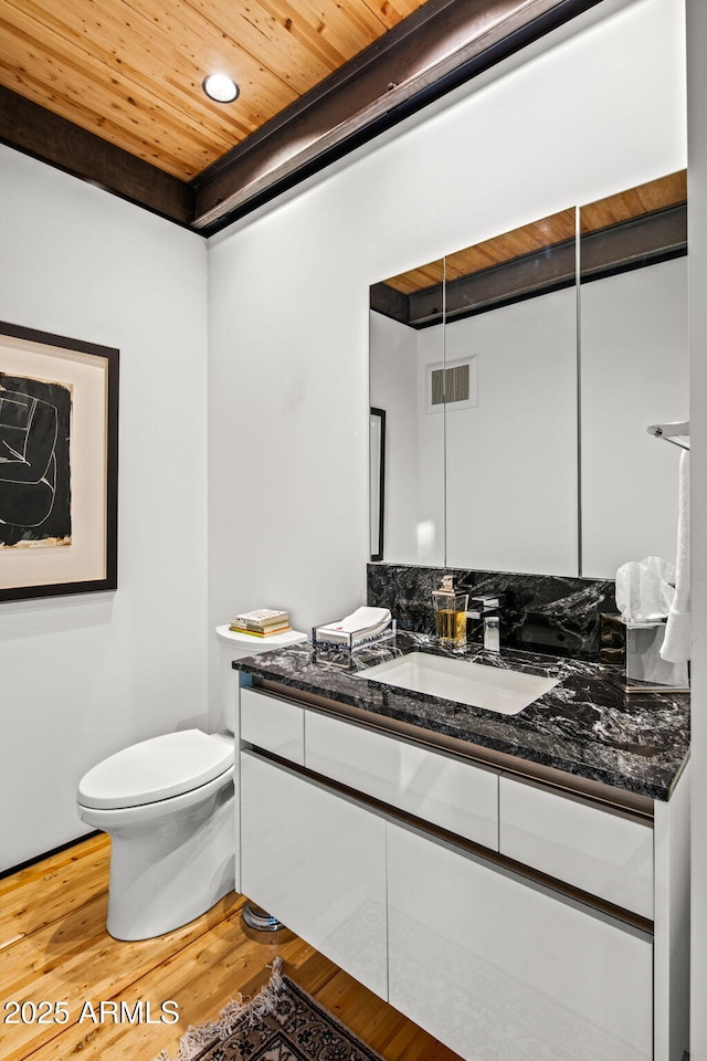 bathroom featuring toilet, wood finished floors, visible vents, vanity, and wood ceiling