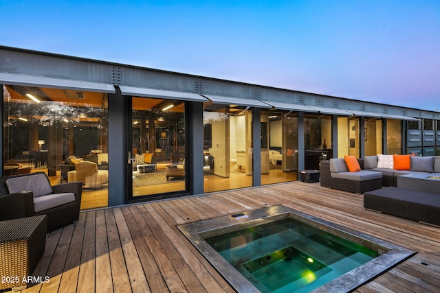 back of house at dusk with hot tub deck surround, a wooden deck, and an outdoor hangout area