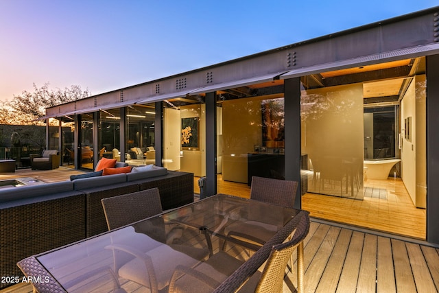 wooden terrace with outdoor dining space and outdoor lounge area