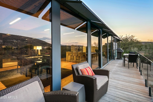 deck at dusk with a grill and exterior bar