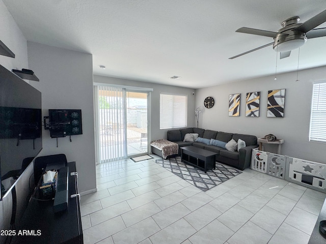 living area with ceiling fan and light tile patterned floors