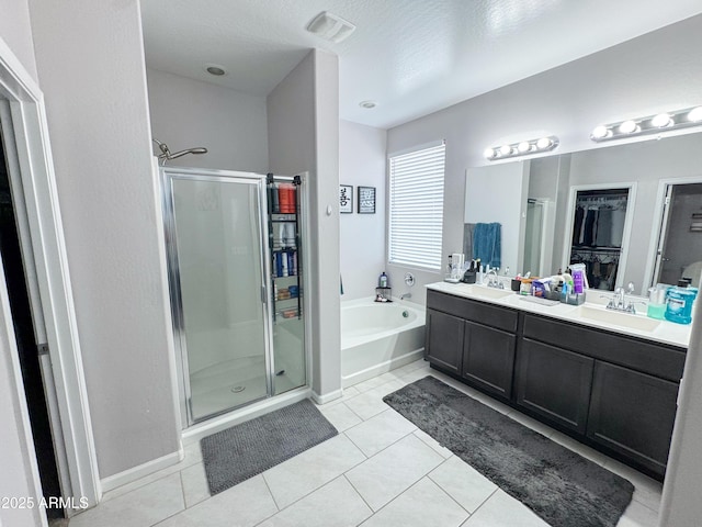 bathroom with double vanity, a sink, a bath, tile patterned flooring, and a shower stall