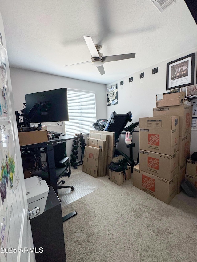 carpeted office featuring a ceiling fan and visible vents