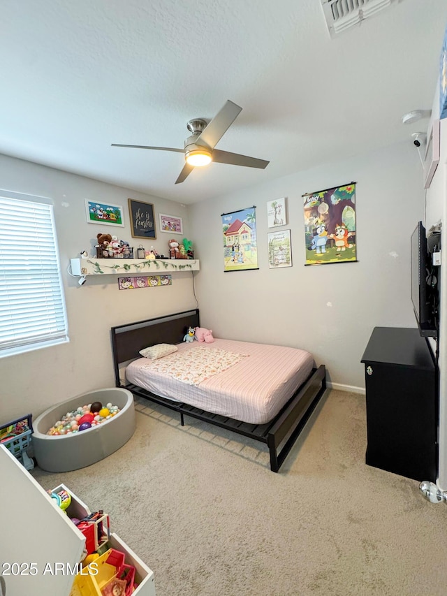 carpeted bedroom featuring ceiling fan and visible vents