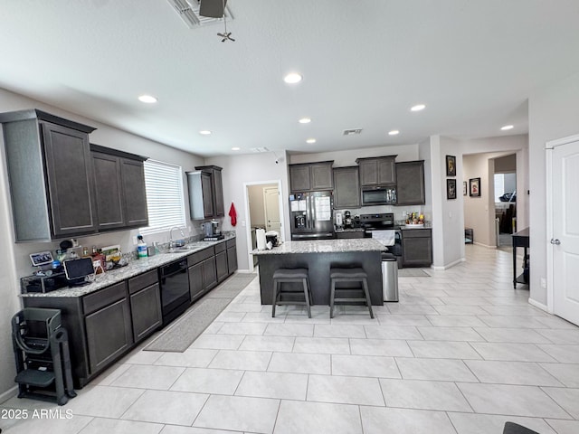 kitchen with recessed lighting, dishwasher, a kitchen bar, a kitchen island, and fridge with ice dispenser