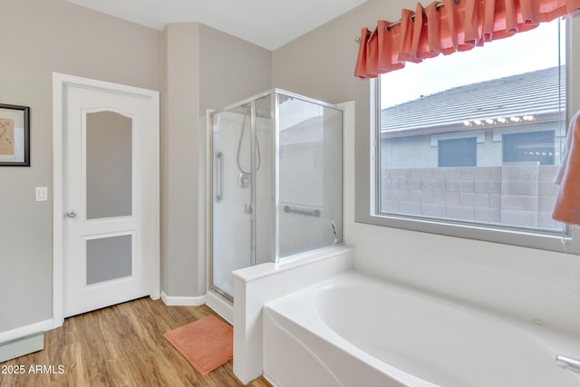 bathroom with hardwood / wood-style flooring and shower with separate bathtub