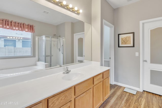 bathroom featuring vanity, separate shower and tub, and hardwood / wood-style floors