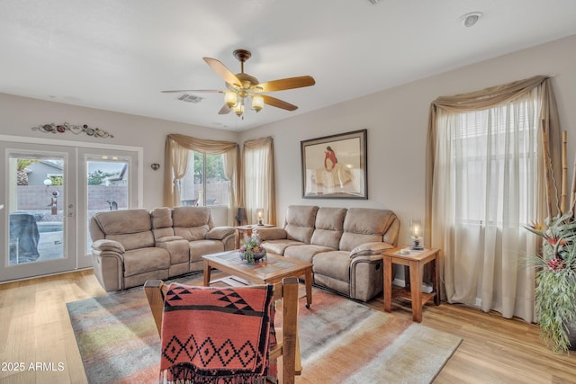 living room featuring french doors, ceiling fan, and light hardwood / wood-style floors