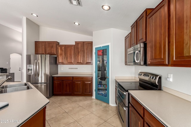 17562 W Desert Sage Dr, Goodyear, AZ 85338 - kitchen with appliances with stainless steel finishes, a sink, lofted ceiling, light countertops, and light tile patterned flooring