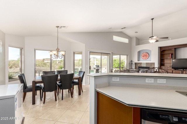 17562 W Desert Sage Dr, Goodyear, AZ 85338 - kitchen featuring a chandelier, vaulted ceiling, light tile patterned flooring, a tiled fireplace, and light countertops
