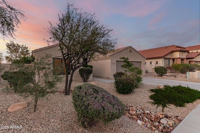 17562 W Desert Sage Dr, Goodyear, AZ 85338 - view of front of home featuring stucco siding, an attached garage, a tiled roof, and driveway
