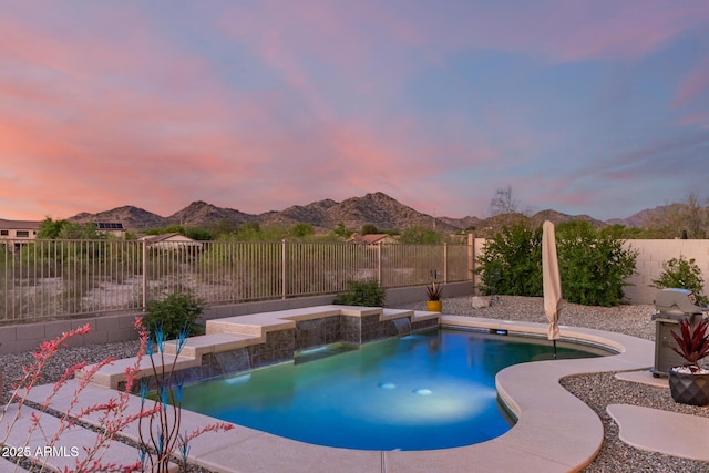 17562 W Desert Sage Dr, Goodyear, AZ 85338 - pool at dusk with a mountain view and a fenced backyard