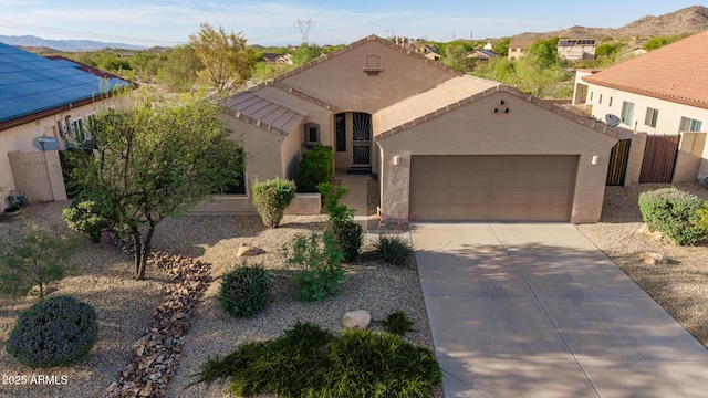 17562 W Desert Sage Dr, Goodyear, AZ 85338 - mediterranean / spanish-style house with driveway, an attached garage, stucco siding, and a mountain view