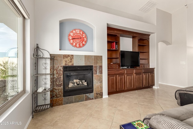 17562 W Desert Sage Dr, Goodyear, AZ 85338 - living area featuring light tile patterned flooring, a fireplace, and baseboards