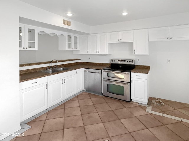 kitchen with white cabinets, stainless steel appliances, light tile patterned flooring, and sink