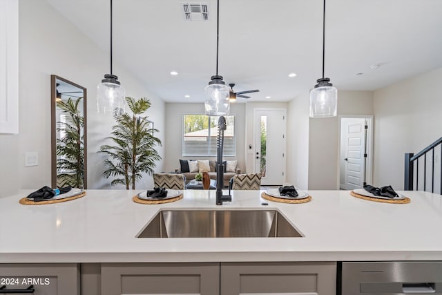 kitchen featuring visible vents, open floor plan, gray cabinets, light countertops, and a sink