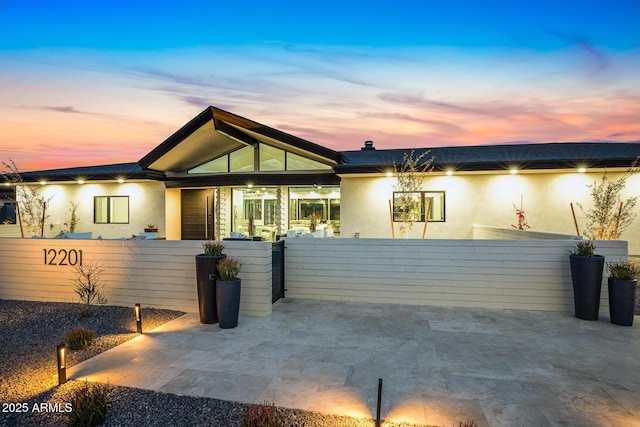 exterior space with a fenced front yard, a gate, and stucco siding