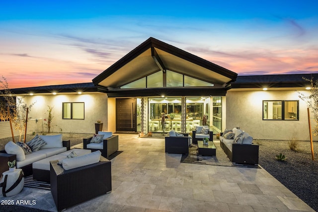 rear view of property with an outdoor living space, a patio, and stucco siding